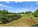 Scenic backyard view of a large field with lush greenery, framed by trees and manicured landscaping at 1028 Southwood Dr, Villa Rica, GA 30180