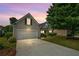 Charming home exterior at dusk, featuring a two-car garage and landscaped yard at 1028 Southwood Dr, Villa Rica, GA 30180