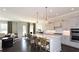 Open kitchen featuring a large center island, pendant lighting, stainless steel appliances, and hardwood flooring at 2905 Medford Drive, Cumming, GA 30041