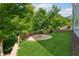 Landscaped backyard with lush grass, a fire pit, and mature trees at 3998 Commodore Dr, Atlanta, GA 30341