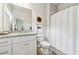 Well-lit bathroom features a granite countertop vanity, toilet, and shower with patterned curtain at 3998 Commodore Dr, Atlanta, GA 30341