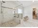 Luxurious bathroom with glass-enclosed shower, marble tile, and dual vanity with seating at 3998 Commodore Dr, Atlanta, GA 30341
