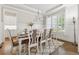 Formal dining room with wainscoting, tray ceiling, large windows, and elegant chandelier at 3998 Commodore Dr, Atlanta, GA 30341