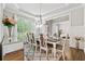 Elegant dining room featuring a tray ceiling, natural light, and seating for eight at 3998 Commodore Dr, Atlanta, GA 30341