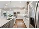 Bright kitchen features stainless appliances, white countertops and cabinets, and view to living area at 3998 Commodore Dr, Atlanta, GA 30341