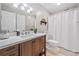 Bathroom with wood vanity, large mirror, and shower with white curtain at 1313 Cobblestone Ln, Woodstock, GA 30189