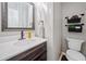 Bathroom featuring a dark wood vanity with quartz countertops and a decorative mirror at 1313 Cobblestone Ln, Woodstock, GA 30189