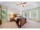 Main bedroom with a ceiling fan, windows, and plush carpeting at 1313 Cobblestone Ln, Woodstock, GA 30189