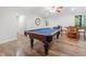Finished recreation room with a pool table, wood flooring, and natural light at 1313 Cobblestone Ln, Woodstock, GA 30189