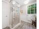 Glass-enclosed shower with stone flooring and a built-in seat offers a spa-like feel at 1313 Cobblestone Ln, Woodstock, GA 30189