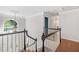 Elegant staircase with white railings, wooden steps, and a decorative chandelier at 1313 Cobblestone Ln, Woodstock, GA 30189