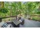 Outdoor living on the wooden deck with comfortable seating surrounded by lush greenery at 1313 Cobblestone Ln, Woodstock, GA 30189