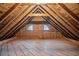 Spacious unfinished attic with wood floors, wood paneled walls, and small arched windows at 1482 N Decatur Ne Rd, Atlanta, GA 30306