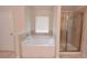 Bathroom featuring a soaking tub, a glass enclosed shower, and a window at 2307 Overlook Ave, Lithonia, GA 30058