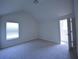 Upstairs bedroom featuring a vaulted ceiling, carpeted floors, and a window at 2307 Overlook Ave, Lithonia, GA 30058