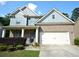 Charming two-story home featuring a brick facade, blue siding, and a two-car garage at 2307 Overlook Ave, Lithonia, GA 30058