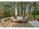 Relaxing back deck featuring outdoor seating surrounded by mature trees at 5725 Brenda Sw Dr, Mableton, GA 30126