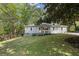 Charming single-story home featuring a light gray exterior, a pink front door and a well-manicured lawn at 5725 Brenda Sw Dr, Mableton, GA 30126