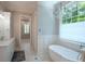 Bright bathroom with a standalone tub, chandelier, and natural light from a large window at 100 Trotters Ridge, Fayetteville, GA 30215