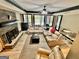 Spacious living room with a stone fireplace, ceiling fan, and multiple leather sofas at 100 Trotters Ridge, Fayetteville, GA 30215