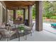 Covered patio area with comfortable seating, an outdoor kitchen, and views of the backyard pool at 100 Trotters Ridge, Fayetteville, GA 30215