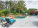 Beautiful backyard pool featuring lounge chairs, lush landscaping, basketball hoop, and a waterfall-style spa at 100 Trotters Ridge, Fayetteville, GA 30215