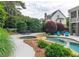 View of the pool area with an adjacent spa, patio furniture, and landscaped surroundings at 100 Trotters Ridge, Fayetteville, GA 30215