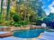 Beautiful backyard pool surrounded by lush landscaping, creating a serene outdoor oasis at 100 Trotters Ridge, Fayetteville, GA 30215