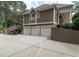 Exterior view showcasing a three-car garage, basketball court, and a stairway leading to an upper deck at 100 Trotters Ridge, Fayetteville, GA 30215
