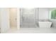 Bathroom featuring a glass shower enclosure and separate soaking tub with sleek, modern fixtures and finishes at 2109 Ella Springs Dr, Covington, GA 30014