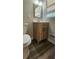 Bathroom features a wood vanity, matching toilet and a window at 2663 Washington Nw St, Atlanta, GA 30318