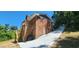 A red brick home features an exterior stairway, with lush, green surroundings and a long driveway at 2663 Washington Nw St, Atlanta, GA 30318