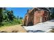 A red brick home features an exterior stairway, with lush, green surroundings and a long driveway at 2663 Washington Nw St, Atlanta, GA 30318