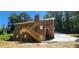 A red brick home features an exterior stairway, with lush, green surroundings and a long driveway at 2663 Washington Nw St, Atlanta, GA 30318