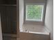 Bathroom features a luxurious tub beneath a window and a separate shower with a glass door at 4805 Madison Point Cir, Austell, GA 30106