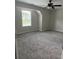A well-lit bedroom featuring plush carpeting and a window offering a view of the outdoors at 4805 Madison Point Cir, Austell, GA 30106