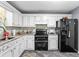 Updated kitchen featuring granite countertops, backsplash, and black appliances at 12 Ranger Se Rd, Cartersville, GA 30121