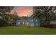 Backyard view of teal-colored house with wood deck and large lawn with sunset at 1328 Hoy Taylor Dr, Norcross, GA 30093