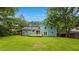 Backyard view of teal-colored house with wood deck and large lawn at 1328 Hoy Taylor Dr, Norcross, GA 30093