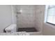 Modern bathroom showcasing a walk-in shower with white marble tile and dark patterned floor at 1328 Hoy Taylor Dr, Norcross, GA 30093