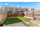 Fenced back yard features artificial turf, a small patio area, and minimal landscaping at 2309 Rolling Trl, Lithonia, GA 30058