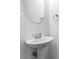 Stylish bathroom with a pedestal sink, elegant mirror, and modern fixtures at 2309 Rolling Trl, Lithonia, GA 30058