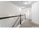 Upstairs hallway featuring neutral decor, a carpeted floor, and stairs with white and black railings at 2309 Rolling Trl, Lithonia, GA 30058