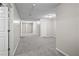 Long hallway with gray carpet, neutral paint, white doors, and ample lighting at 1027 Regency Dr, Acworth, GA 30102