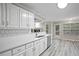 Open kitchen showcasing white cabinets, stainless steel appliances, and view into living room and breakfast nook at 1027 Regency Dr, Acworth, GA 30102