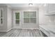 Bright breakfast nook with light gray walls, door to deck, window, gray wood-look flooring, and modern light fixture at 1027 Regency Dr, Acworth, GA 30102