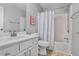 Bright bathroom with white vanity, framed mirror, and shower-tub combo with patterned curtain at 1067 Brownstone Dr # 23, Marietta, GA 30008