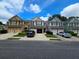 Inviting townhome exterior with a brick-accented garage and well-manicured lawns under a beautiful sky at 1067 Brownstone Dr # 23, Marietta, GA 30008