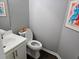 Compact powder room with a white vanity, toilet, and stylish artwork, offering a practical yet refined space at 1067 Brownstone Dr # 23, Marietta, GA 30008
