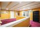 Basement landing with wood-beamed ceiling, vibrant yellow walls, plum carpet, and backyard access at 2004 Spicers Ln, Woodstock, GA 30189
